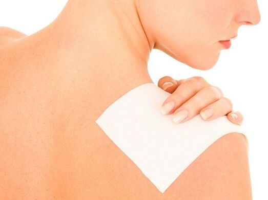 Žena koristi flaster za bolove u leđima